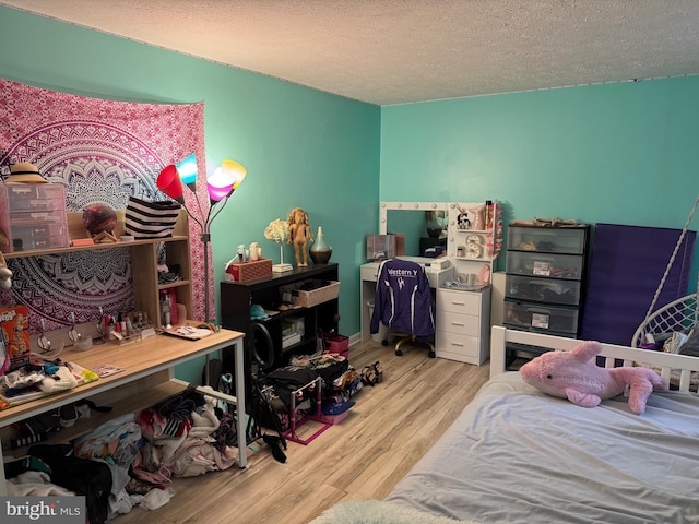 bedroom with a textured ceiling and wood finished floors