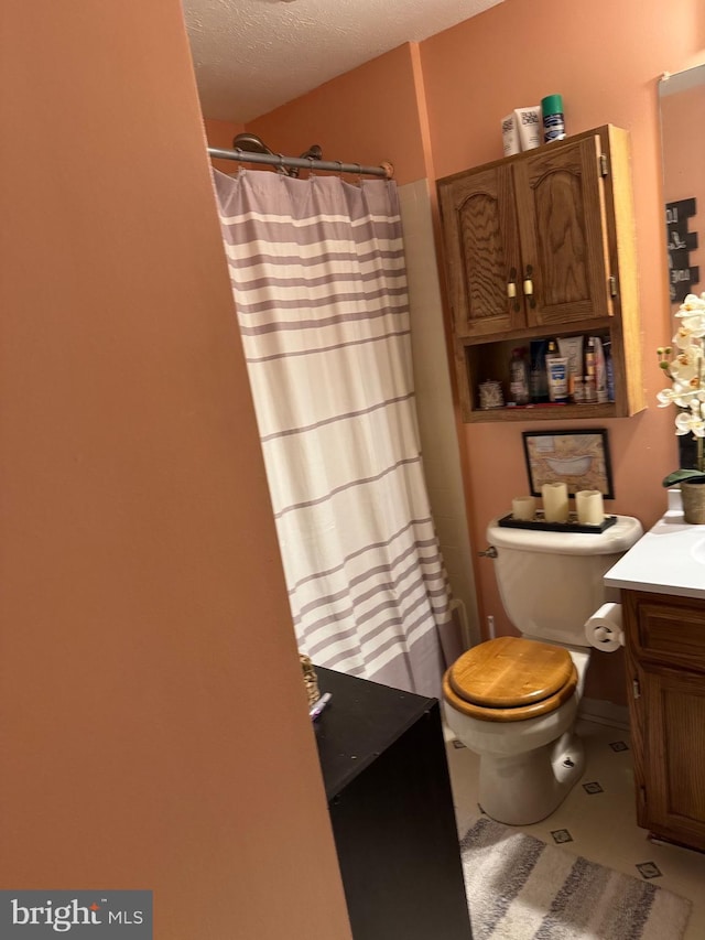 full bath featuring vanity, a shower with curtain, tile patterned flooring, a textured ceiling, and toilet