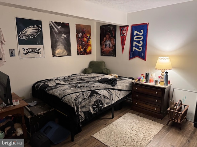 bedroom with wood finished floors and a textured ceiling