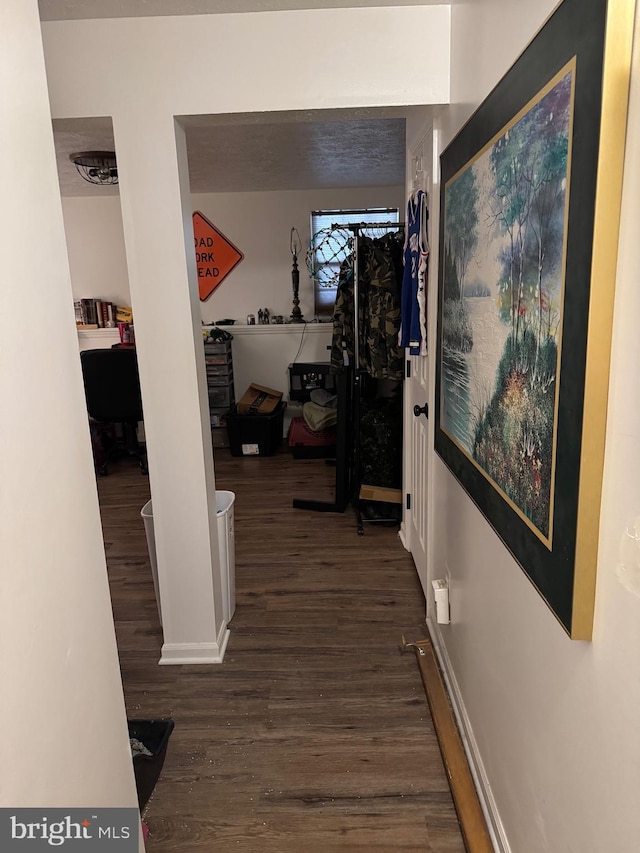 hallway with baseboards and wood finished floors