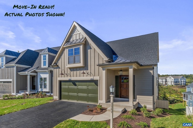 view of front of home with board and batten siding, driveway, and a standing seam roof