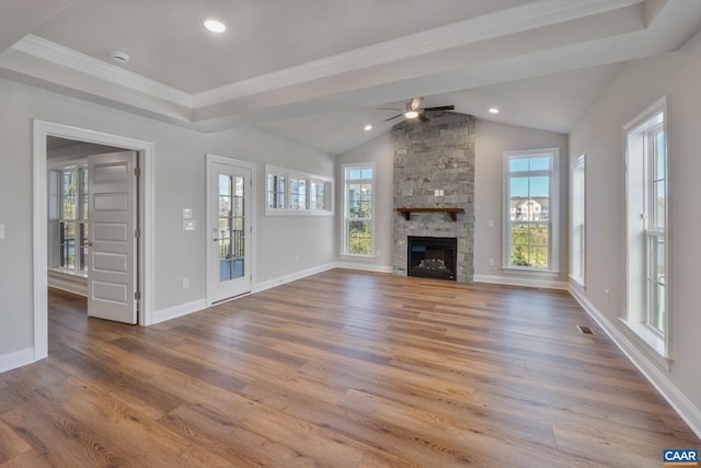 unfurnished living room with ceiling fan, plenty of natural light, lofted ceiling, and wood finished floors