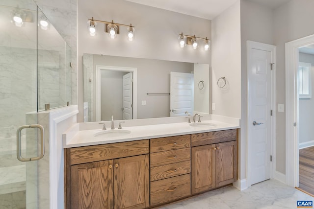 full bathroom featuring a shower stall, marble finish floor, and a sink