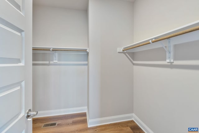 walk in closet with visible vents and wood finished floors