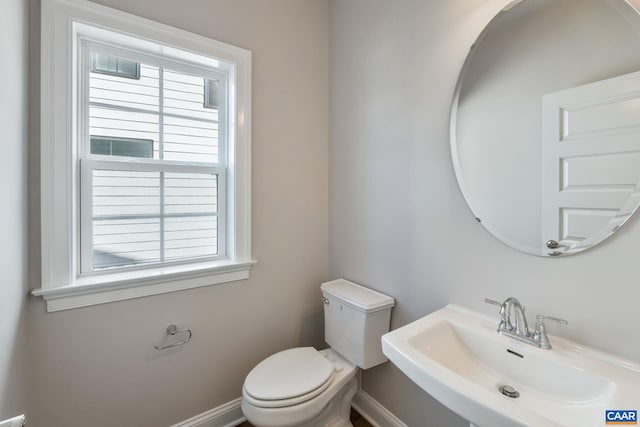 bathroom with toilet, baseboards, and a sink