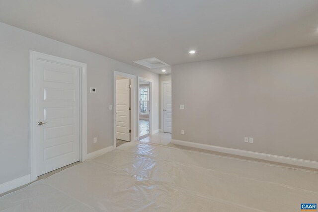 spare room featuring recessed lighting and baseboards