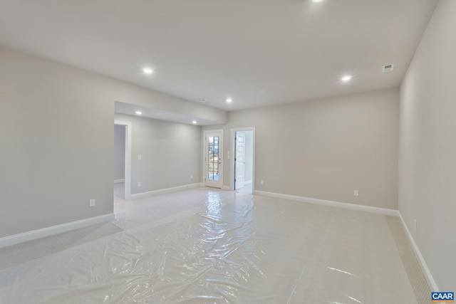 spare room featuring recessed lighting and baseboards