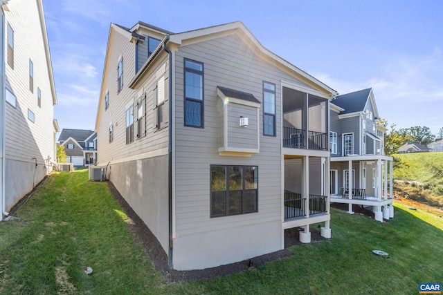 rear view of property with a yard and central AC unit