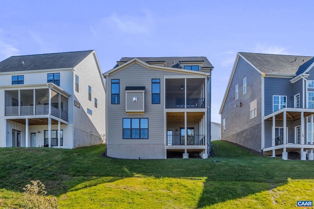 back of property with a yard and a sunroom