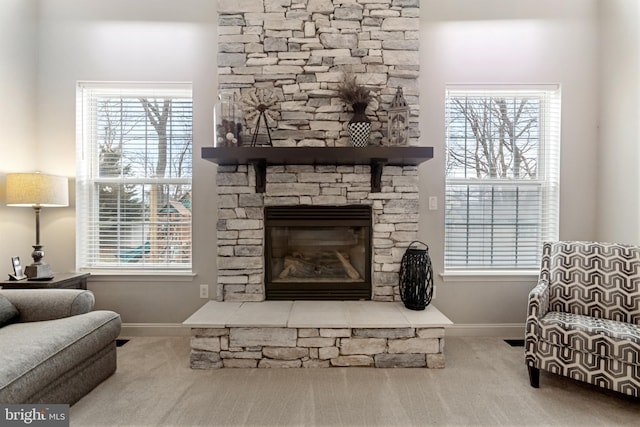 living room with a fireplace, a healthy amount of sunlight, baseboards, and carpet floors