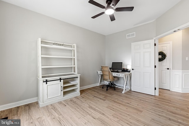 unfurnished office with light wood-type flooring, visible vents, baseboards, and a ceiling fan