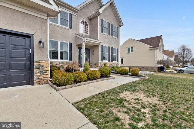 exterior space with stucco siding, stone siding, and a front lawn