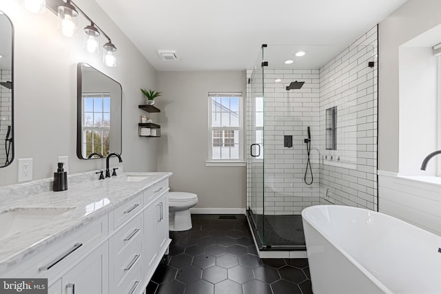 full bathroom featuring a sink, a freestanding tub, a healthy amount of sunlight, and tile patterned flooring