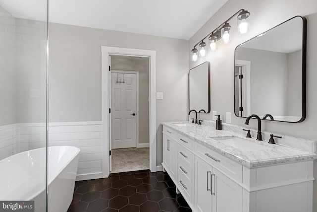 bathroom featuring double vanity, tile patterned flooring, a freestanding bath, and a sink