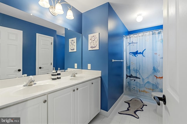 full bathroom with double vanity, baseboards, tile patterned floors, and a sink