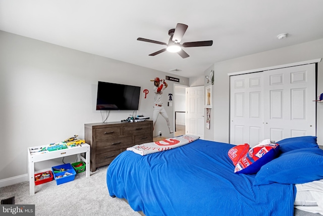 carpeted bedroom featuring a closet, baseboards, and ceiling fan