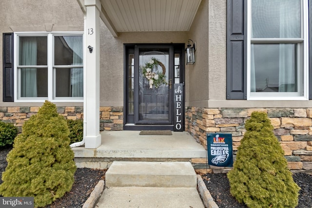 property entrance with stucco siding and stone siding