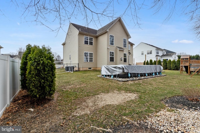 back of house featuring a fenced in pool, a yard, central AC, and a fenced backyard