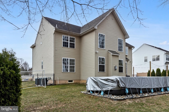 back of property with a yard, fence, and a fenced in pool