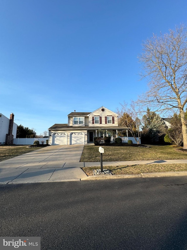 view of front of house with a garage, concrete driveway, a front yard, and fence