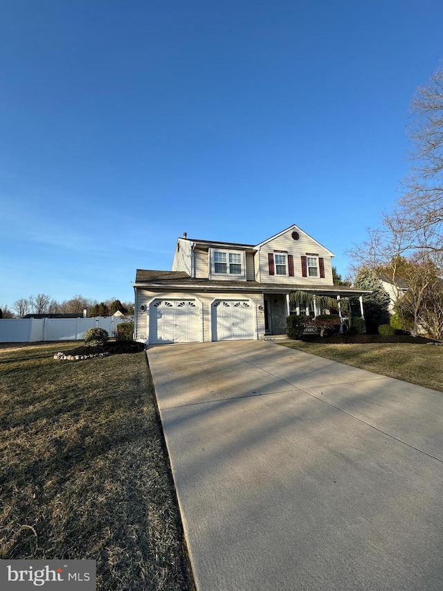 traditional-style house with a front lawn, driveway, and fence