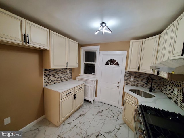 kitchen with a sink, baseboards, stainless steel range with gas cooktop, and marble finish floor