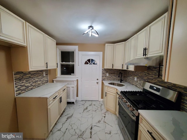 kitchen featuring stainless steel gas range, a sink, light countertops, under cabinet range hood, and marble finish floor