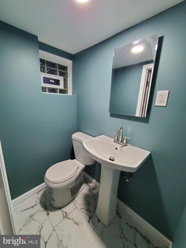 bathroom featuring baseboards, toilet, and marble finish floor