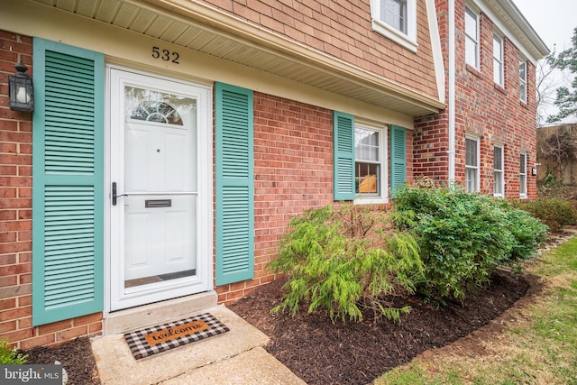 doorway to property with brick siding