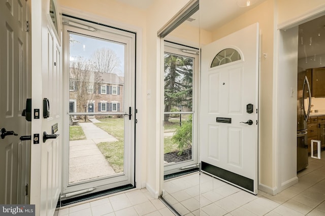 foyer entrance featuring light tile patterned floors and baseboards