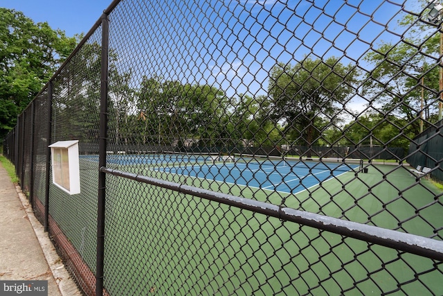 view of sport court featuring fence