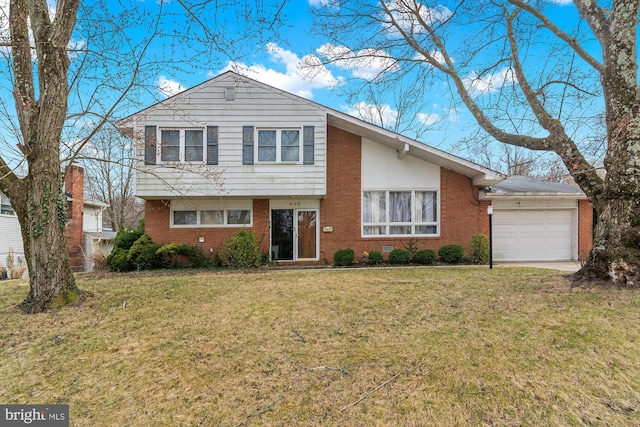 tri-level home with a front lawn, an attached garage, and brick siding