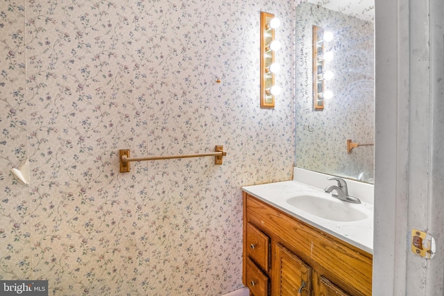 bathroom with vanity and wallpapered walls