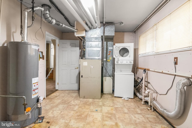 basement featuring stacked washer and clothes dryer and water heater