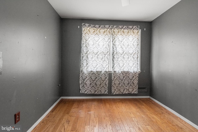 unfurnished room featuring baseboards and light wood-style floors