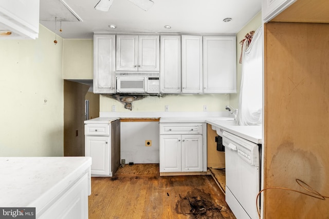 kitchen with white appliances, light countertops, dark wood-style flooring, and white cabinetry