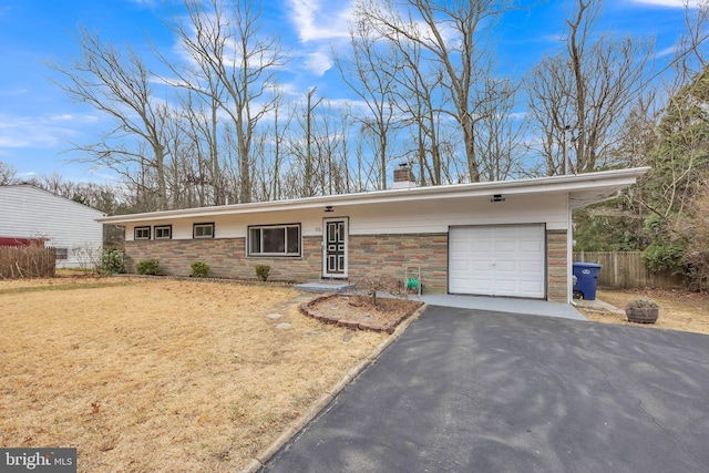 view of front of house with fence, aphalt driveway, a chimney, a garage, and stone siding