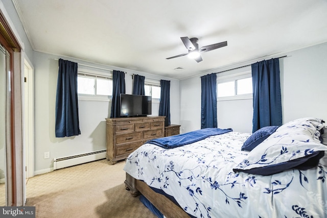 bedroom featuring light carpet, baseboard heating, multiple windows, and ceiling fan