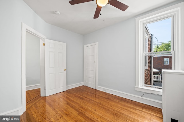 unfurnished bedroom featuring wood finished floors, baseboards, and ceiling fan