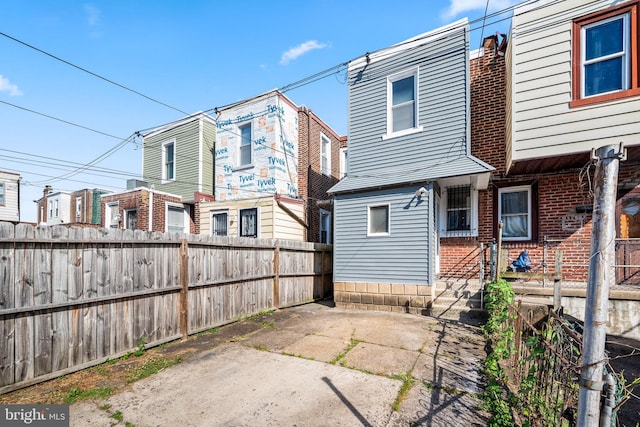 rear view of house with brick siding, fence private yard, and a patio area