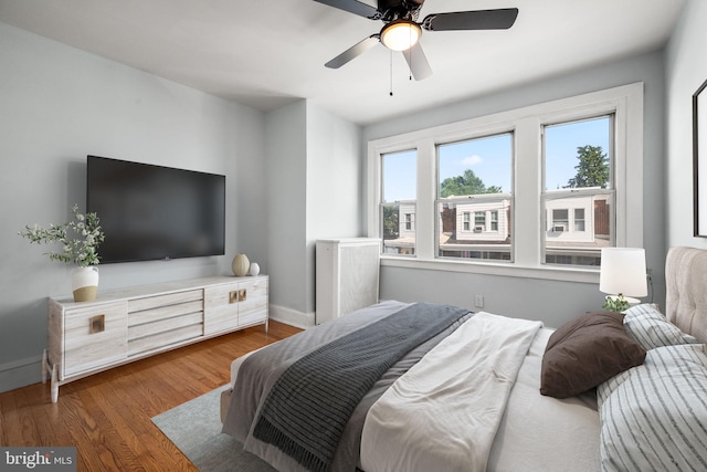 bedroom featuring wood finished floors, baseboards, and ceiling fan