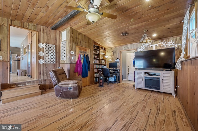 interior space with ceiling fan, wood finished floors, wood ceiling, and wood walls