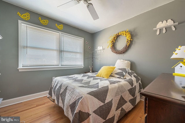 bedroom featuring wood finished floors, baseboards, and ceiling fan