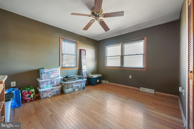 unfurnished room featuring visible vents, baseboards, a ceiling fan, and hardwood / wood-style flooring