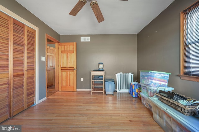 interior space featuring wood finished floors, a ceiling fan, visible vents, and a healthy amount of sunlight