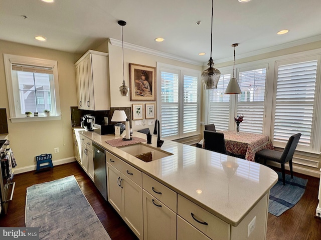 kitchen featuring a sink, a peninsula, dishwasher, baseboards, and white cabinets