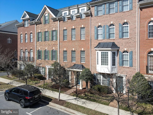 view of front of property featuring brick siding and a standing seam roof