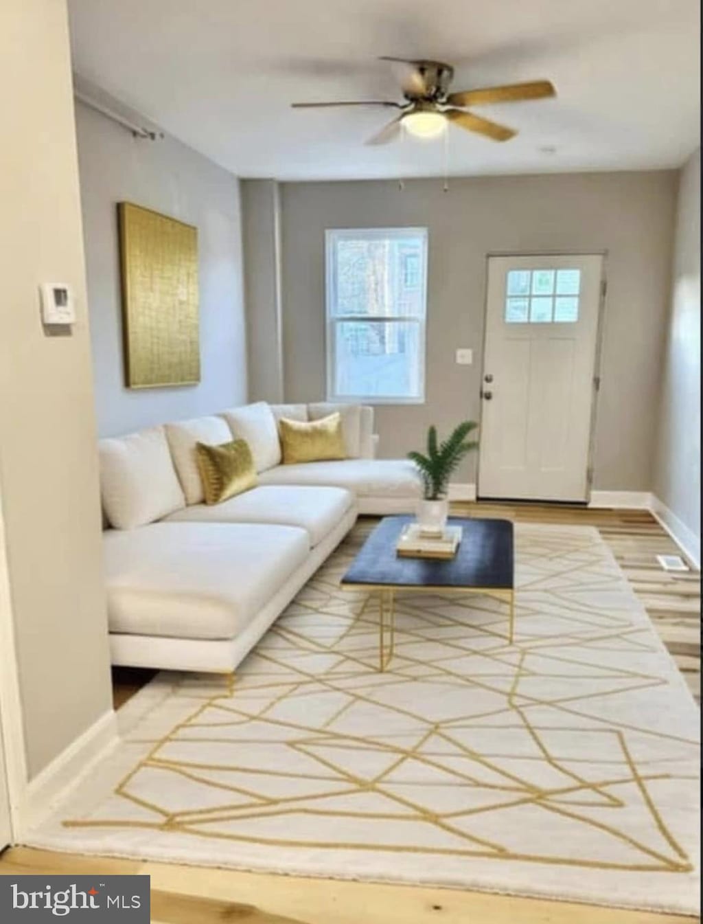 living area with wood finished floors, baseboards, plenty of natural light, and ceiling fan