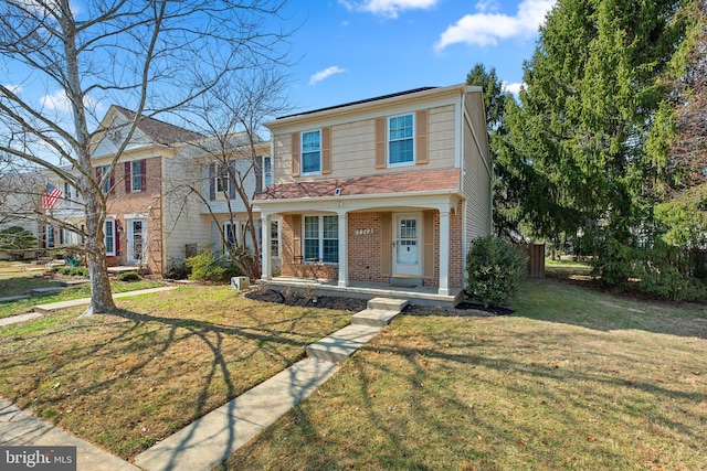 view of front of property with brick siding, a porch, and a front lawn