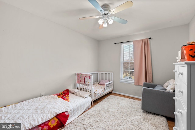 bedroom with baseboards, ceiling fan, and wood finished floors